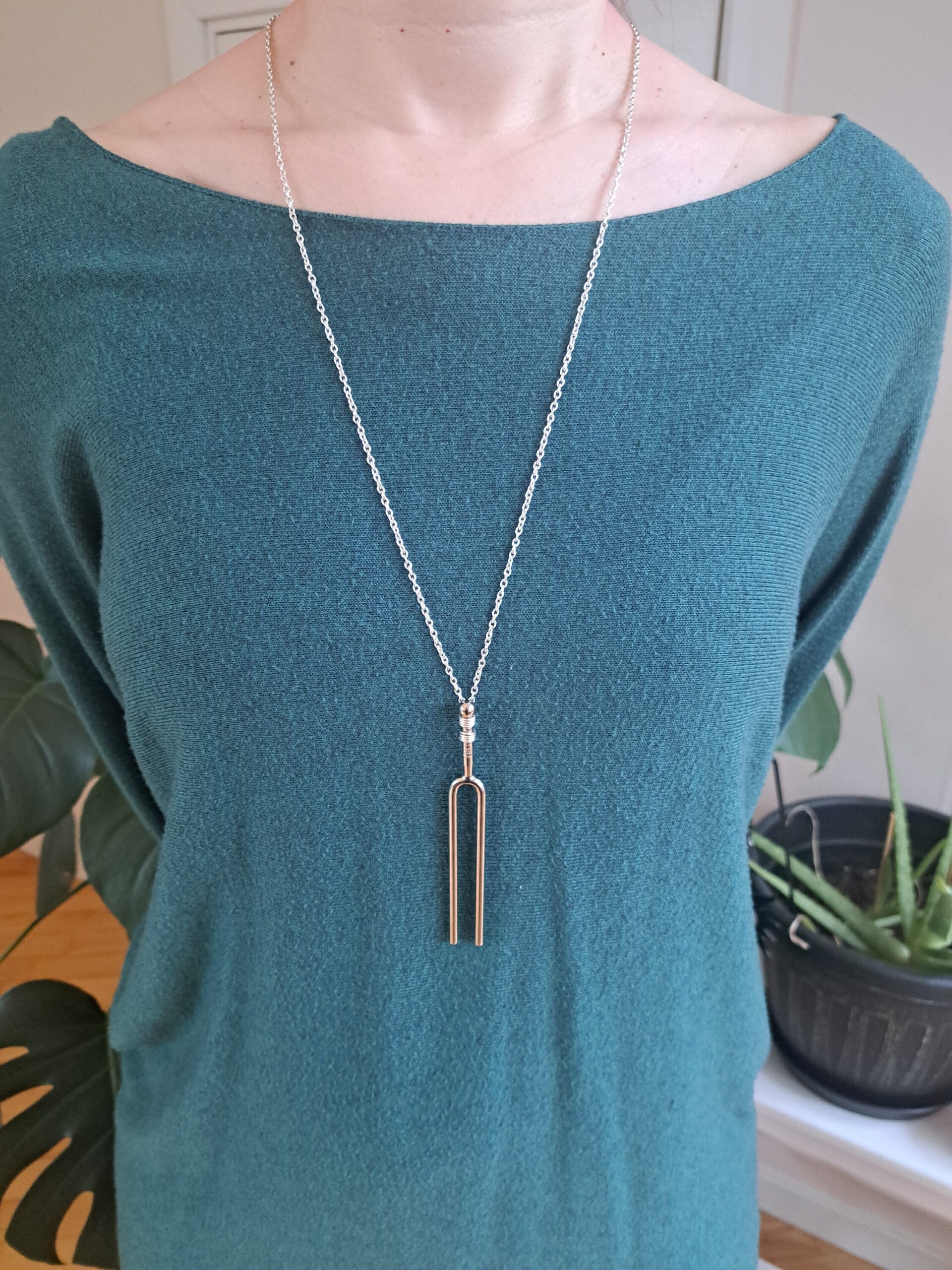 Tuning Fork Necklace being worn on a long chain